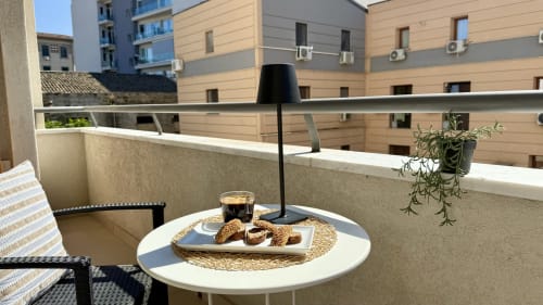 Balcone dell'appartamento a Palermo con tavolo da pranzo, caffè, pasticcini e vista sulla città