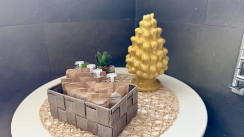 Elegante composizione con cesto intrecciato, succulenta in vaso, ananas dorato decorativo e prodotti wellness in appartamento a Palermo