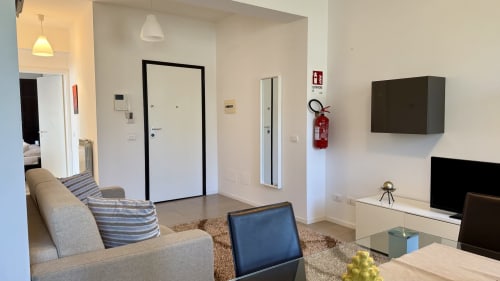 Moderno soggiorno di appartamento a Palermo con divano grigio, TV a schermo piatto e arredi contemporanei