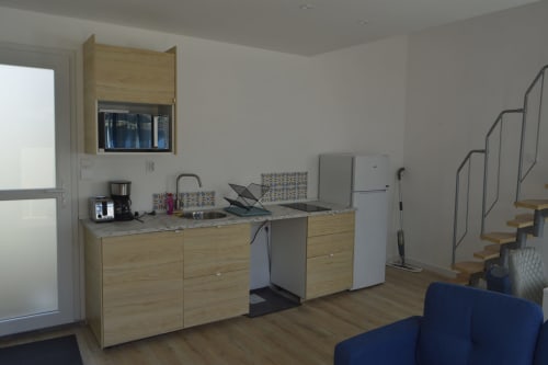 Cuisine moderne du gîte maison 1 à la Résidence des dunes, Landéda avec meubles en bois et électroménagers en acier inoxydable