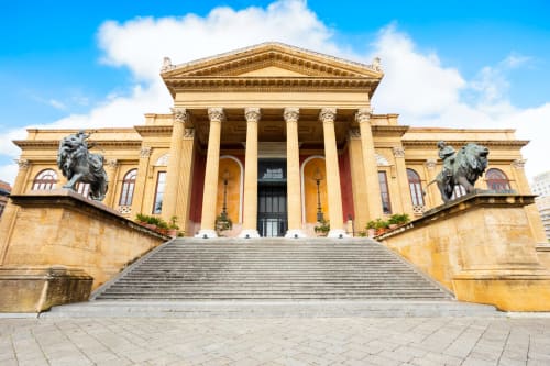 Maestoso edificio museo neoclassico con colonne dorate e statue di leoni a Palermo, Italia