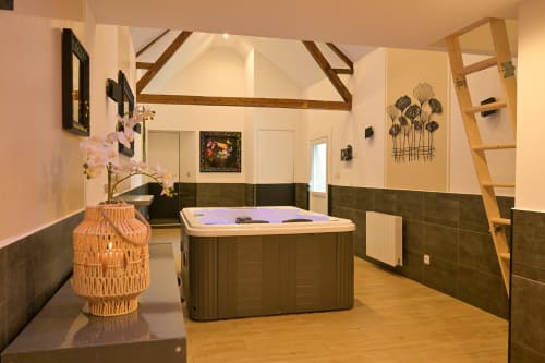 Modernes Spa im Hotel Ziane in der Normandie mit dunkelgefliester Whirlwanne und Ambienteleuchtung