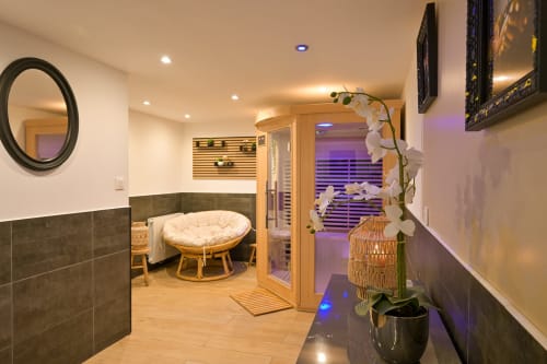 Ziane Hotel Spa mit Holzstuhl, Orchidee, violettem Ambientlicht und Saunaeingang in der Normandie