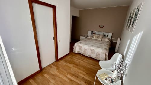 Double bedroom at Hostal Estació in Puigcerdà with wooden floor, bed, desk, and mountain views