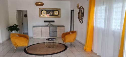 Salon moderne de la Kaz Kafe B&B à Mamoudzou avec chaises orange, table ronde et décoration contemporaine