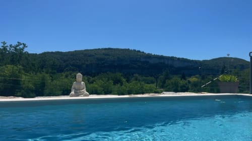 Villa de luxe avec piscine et statue de Bouddha surplombant les vertes montagnes du Lot, France