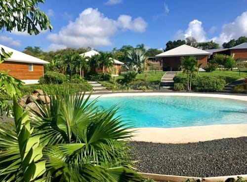 Zone de piscine des Cottages du Lagon à Saint-François, Guadeloupe avec bungalows tropicaux, piscine style lagon turquoise et végétation luxuriante