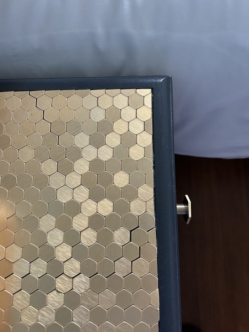 Detail of the bedside table customized with gold hexagonal tiles, in the Les Inséparables guest room at Clos d'Azel, with modern amenities