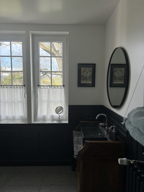 Elegant bathroom with garden view and black wood paneling at Clos d'Azel, a guest house in Alsace