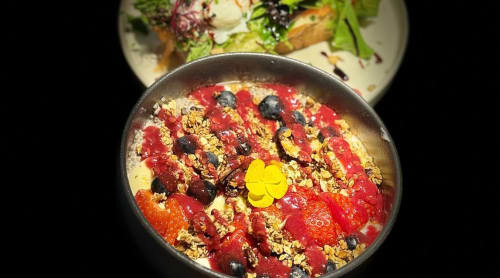 Bol de petit-déjeuner gourmand au Clos du Lac avec granola, fruits frais et fleurs comestibles, Veyrier-du-Lac