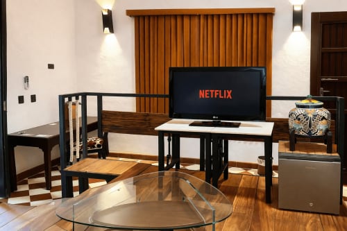 Modern hotel room at Villa Merida with flat-screen TV, black furniture, and wooden accents in Merida, Mexico