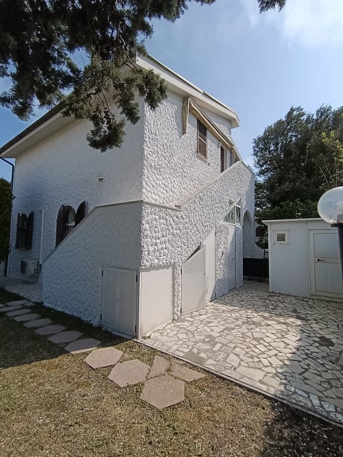 Edificio residenziale in mattoni bianchi con ingresso garage e corte pavimentata ad Ancona, Italia