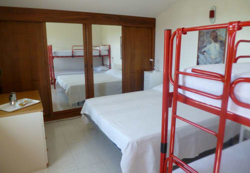 Ampia camera da letto ad Ancona con letti a castello rossi, biancheria bianca, armadio con specchio e aria condizionata