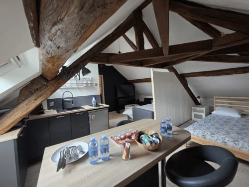 Chambre mansardée au Relais Saint-Laurent avec poutres apparentes, kitchenette et lit à Chevreuse