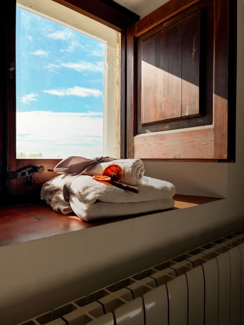Cozy windowsill at Mas Ribas Hotel in Palamos with rolled towels, beach accessories, and sea view through wooden framed