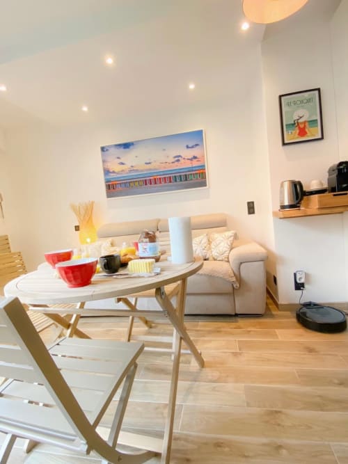 Intérieur moderne d'un studio avec table à manger, canapé, cuisine et décoration thème plage chez Hébergements C&C à Angres,
