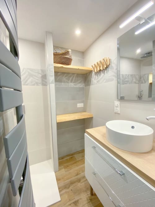 Salle de bain moderne dans l'appartement d'Angres avec douche à l'italienne, vasque ronde, meuble-lavabo en bois et sèche-serviettes électrique