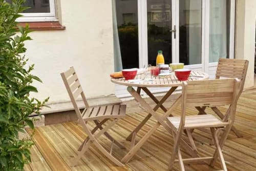 Coin repas ensoleillé avec mobilier en bois et table dressée pour le petit-déjeuner aux Hébergements C&C, Angres
