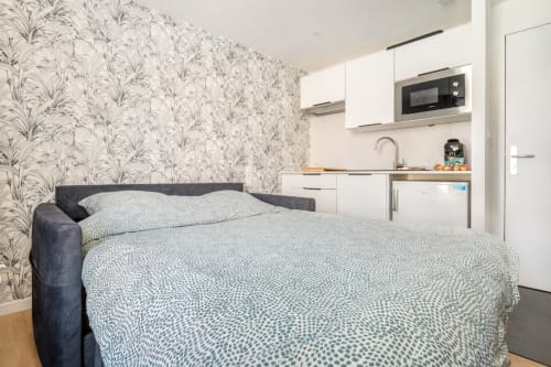 Studio moderne aux Hébergements C&C à Angres avec canapé-lit, papier peint à motifs et kitchenette équipée