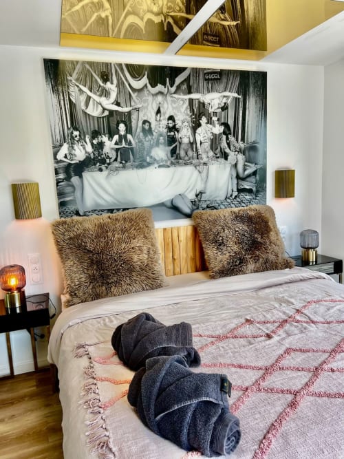Chambre luxueuse de l'hôtel Angres avec oreillers en fourrure, art moderne au-dessus du lit, accents dorés et équipements Jacuzzi