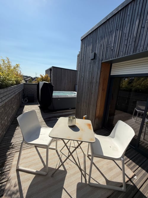 Terrasse contemporaine sur le toit des Hébergements C&C à Angres avec coin détente, bain à remous et architecture moderne sous ciel dégagé