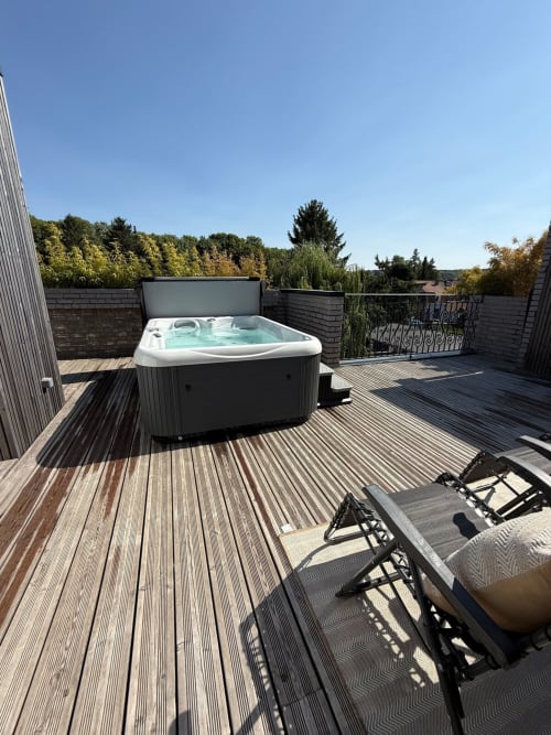 Terrasse avec jacuzzi privé, terrasse en bois, transats et vue sur les arbres aux Hébergements C&C, Angres