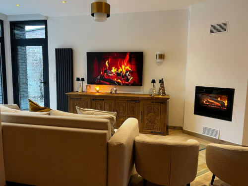 Salon moderne de l'appartement Chez mamie à Angres avec cheminée, TV, mobilier crème et éclairage ambiant