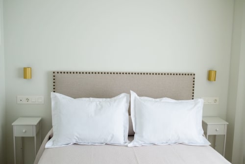 Cama doble impecable con almohadas blancas y cabecero beige en habitación del Hotel Alcazaba Salobrena