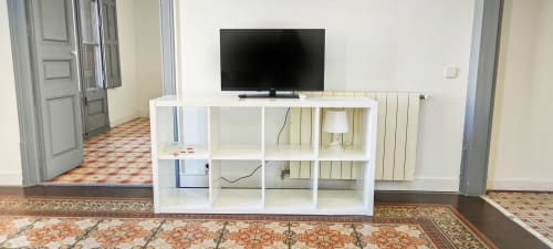Moderno mueble blanco con televisor en salón de apartamento en Barcelona, distrito del Eixample