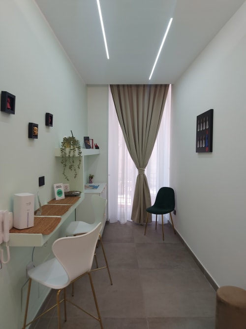 Modern guest room at Pignasecca Domus Naples B&B with white desk, plants, contemporary seating, and large windows with drapes