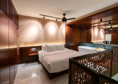 Luxury bedroom at Villa Merida Boutique Hotel in Merida with wood furnishings, white bedding, and modern amenities