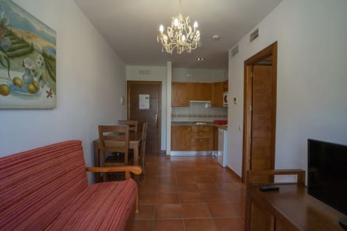 Open-plan apartment in San José-Níjar with living area, dining table, kitchenette, and wooden doors