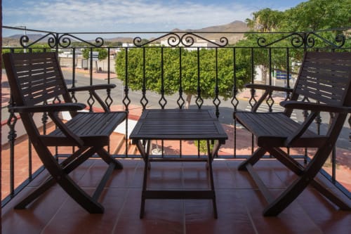 Black wrought iron furniture on terrace with city views at Alojamientos Carolina y Vanesa, San José, Níjar