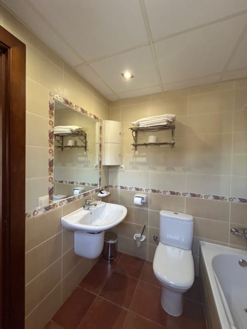 Modern bathroom with pedestal sink, toilet, bidet, and towel racks in Alojamientos Carolina y Vanesa, San José