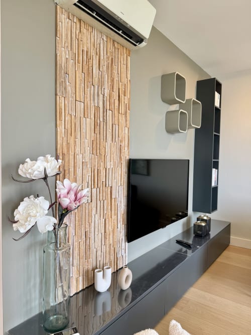 Salon moderne de l'appartement SoleMare avec TV écran plat, mur en bois et fleurs fraîches sur console médias noire