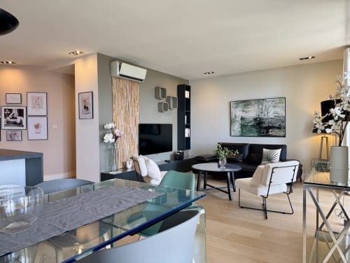 Salon moderne ouvert du SoleMare à Alata : salle à manger, espace détente, télévision, œuvres d'art et vue sur mer