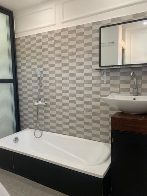 Salle de bain moderne de la mini-suite F7 à la Résidence hôtelière Ôkèrè Ôburu, Lomé avec carrelage à damier, baignoire blanche et vasque