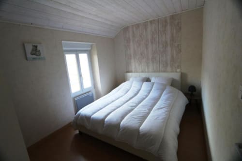 Chambre lumineuse à l'Appart'Hôtel Cholet avec literie blanche, fenêtre et équipements modernes