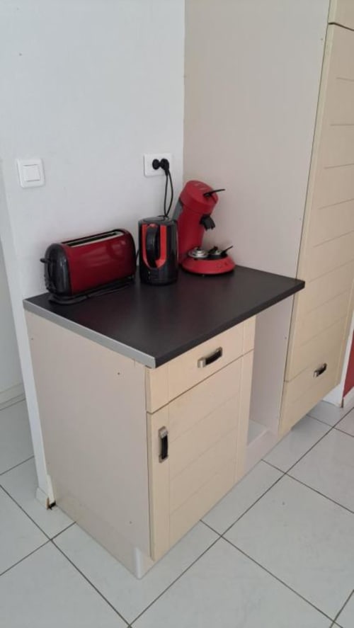 Red kitchen appliances on black countertop in Appart'Hôtel villa kitchenette, Cholet