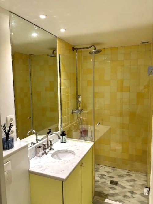 Baño moderno con azulejos amarillos, tocador de mármol, espejo grande y ducha tipo walk-in, apartamento ALDARO París cerca del Louvre