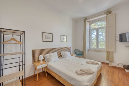Quarto luminoso em Monte da Lua, Sintra com cama de madeira, roupa branca, vista pela janela, TV e assoalho em madeira
