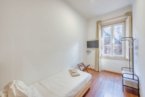 Quarto luminoso no apartamento Vale da Lua, Sintra, com cama individual, piso de madeira, TV e vista para a serra pela janela ampla