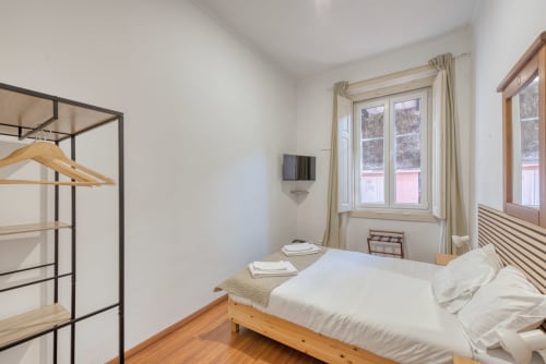 Quarto moderno no apartamento Vale da Lua, Sintra, com cama de madeira, TV, vista para as montanhas e decoração minimalista