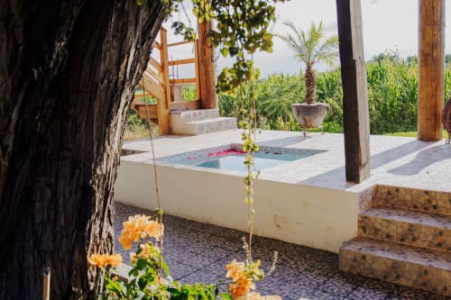 Vista del jardín de la villa Hotel El Porvenir con piscina, arquitectura de madera y exuberante vegetación tropical en Querétaro
