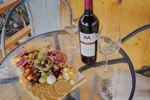 Tabla de quesos y embutidos con vino en la villa Hotel El Porvenir de Querétaro, con carnes, quesos, aceitunas y galletas