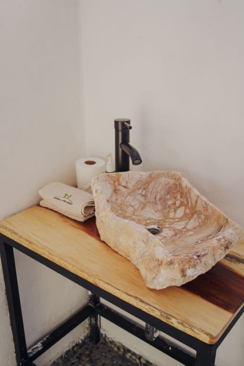 Lavamanos de piedra con grifo negro sobre mostrador de madera en la villa Hotel El Porvenir, Querétaro