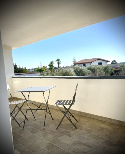 Balcone con tavolo e sedie affacciati su uliveti e campagna presso B&B Hélios, Nardò, Italia