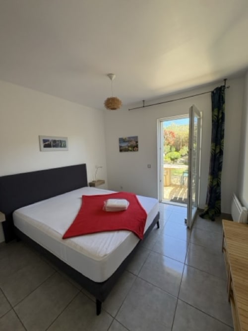 Camera da letto moderna con balcone vista montagna presso Conciergerie De Porticcio, affitto appartamenti Corsica