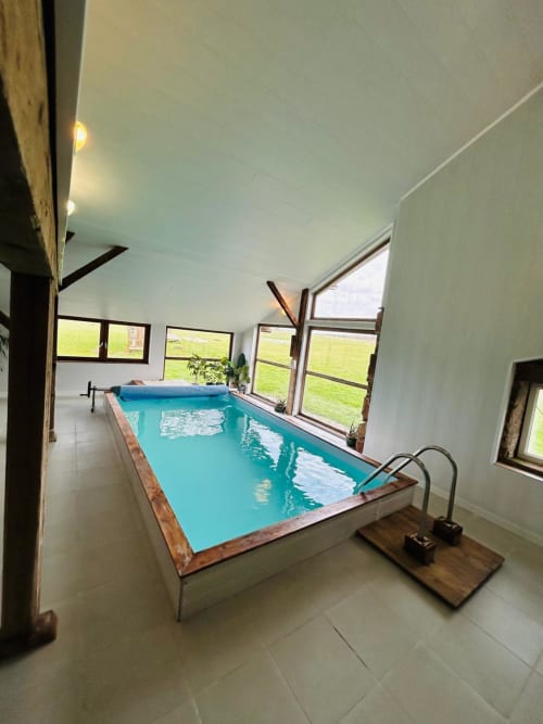 Piscine intérieure chauffée à la Conciergerie des Lacs à Gérardmer avec vue sur le jardin