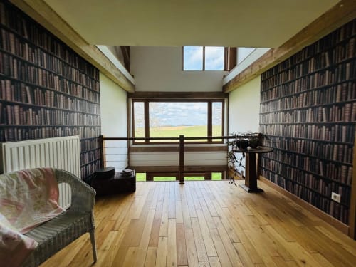 Bibliothèque avec étagères du sol au plafond, parquet bois, vue sur lac et jardin à La Conciergerie des Lacs
